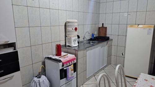 eine kleine Küche mit Spüle und Kühlschrank in der Unterkunft Morada dos Anjos in Aparecida