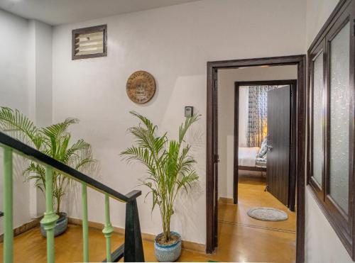 a hallway with two potted plants and a door at Haveli Palace - 2BHK Luxury Apartment in Udaipur