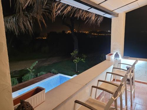 a patio with two chairs and a swimming pool at casa entre mer et montagne in Arcos de la Frontera