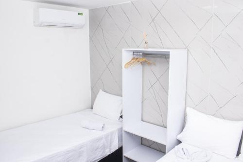 a white room with a mirror and a bed at Hotel Mall plaza in Santa Marta