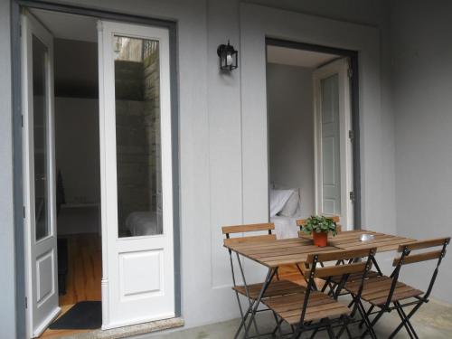 une table et des chaises en bois à côté d'une maison dans l'établissement Your Place Porto II, à Porto