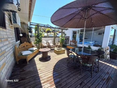a patio with an umbrella and a table and chairs at Casa de pedra in Arroio do Silva