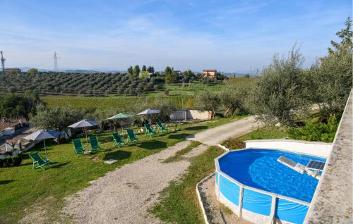 an external view of a swimming pool in a yard with chairs at Amazing Apartment In Moscufo With Wifi in Moscufo