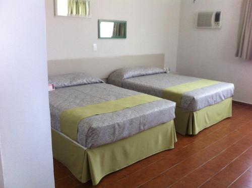 two beds sitting in a room with at Dorados Conventions & Resort in Oaxtepec