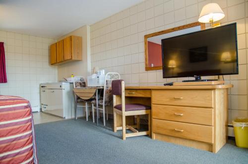 a kitchen with a desk with a television on it at Plains Motel in Brooks