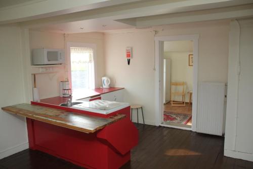 a kitchen with a red island in a room at Hofdi Guesthouse in Húsavík