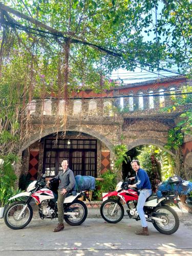 two men sitting on motorcycles in front of a building at Sầm Sơn Boutique Hotel Phan Thiết in Phan Thiet