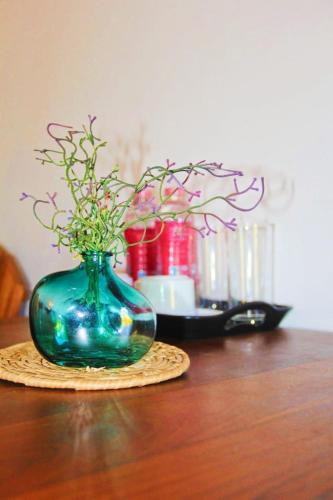 a blue vase with flowers in it on a table at Seeing Green Udawalawa in Udawalawe