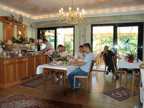a group of people sitting at tables in a restaurant at Hotel zum Rehberg in Kastellaun