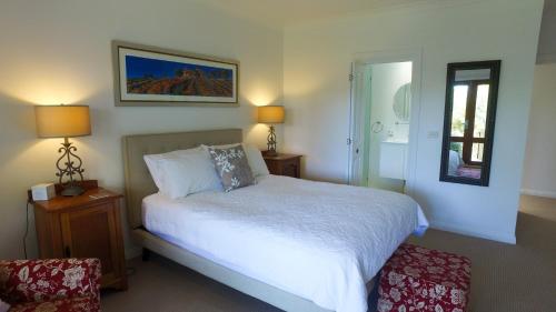 a bedroom with a bed and two lamps and a window at The Ridge Retreat at Mollymook in Mollymook