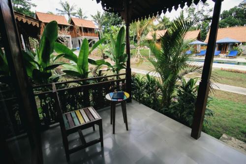 a room with a balcony with a table and a bench at Bhalance Retreat in Padangbai