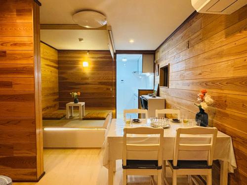 a dining room with wooden walls and a table and chairs at Lapis House 101 - 1F in Tokyo