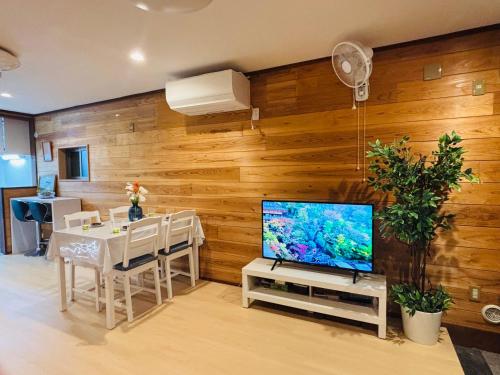 a living room with a television and a table with chairs at Lapis House 101 - 1F in Tokyo