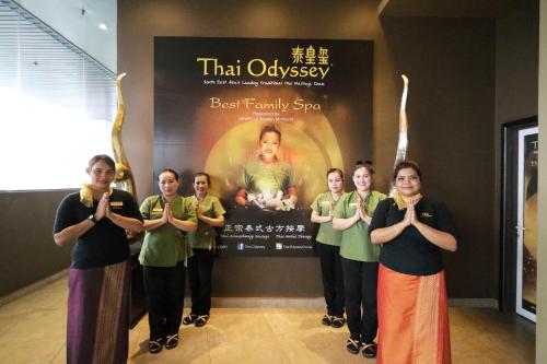 a group of women standing in front of a sign at The Guest Hotel & Spa in Port Dickson