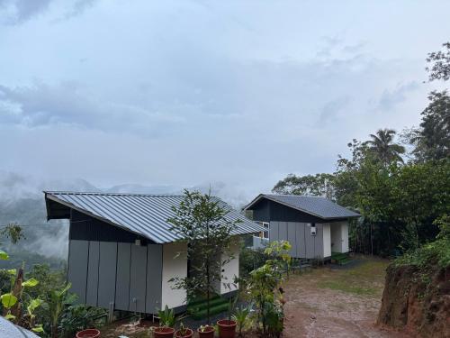 a couple of buildings in the middle of a forest at Serenehills Retreat in Idukki