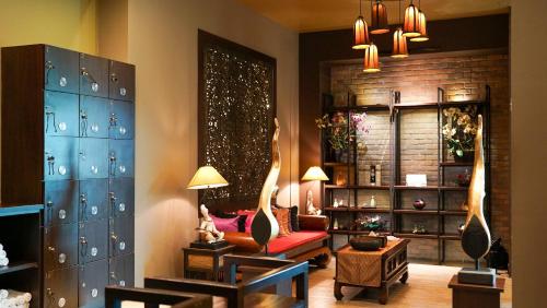a living room with a red couch and a chair at The Guest Hotel & Spa in Port Dickson
