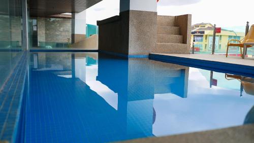 a swimming pool with a chair in the water at The Guest Hotel & Spa in Port Dickson