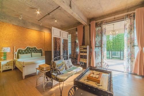 una habitación con un dormitorio con una cama y una mesa en Danxia Mountain Wuyou Tongjinzhai, en Yaoshan