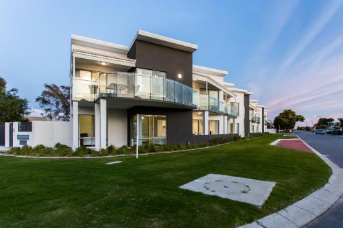 a large building with a lawn in front of it at Reflections By Rockingham Apartments in Rockingham