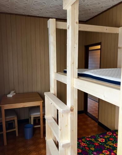 a room with a bunk bed and a desk at ゲストハウス黒島 in Wajima