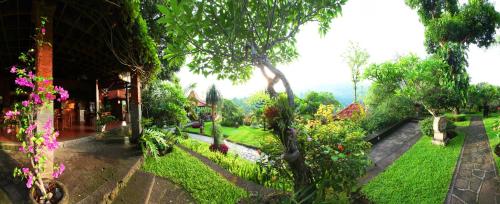 a view of a garden with trees and flowers at Shanti Natural Panorama View Hotel in Singaraja