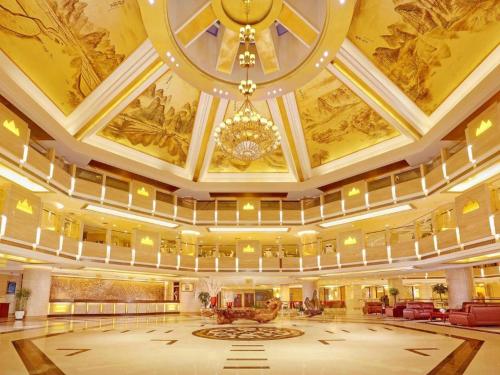 a large room with a ceiling with a chandelier at Yangshuo Greenlotus Hotel in Yangshuo