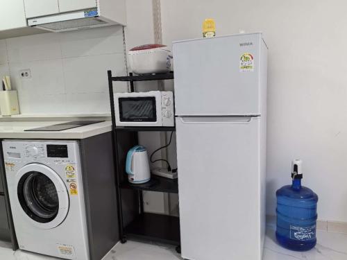 a kitchen with a washing machine and a refrigerator at OYUSTAY Clark Terrace condo Staycation with 2 beds near airport HANN CASINO in Fort Stotsenburg