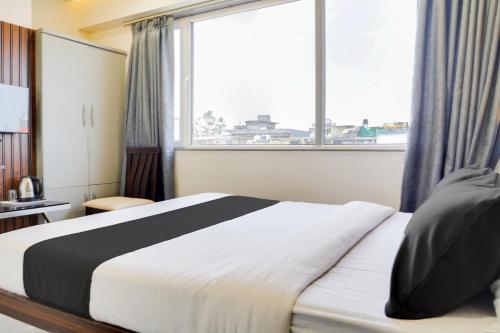 a bedroom with a bed and a large window at Super Collection O Panchvati Regency in Bhopal