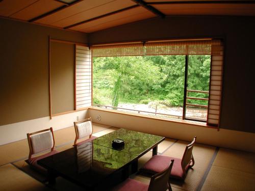a dining room with a table and chairs and a window at Rankeisou in Sanjo