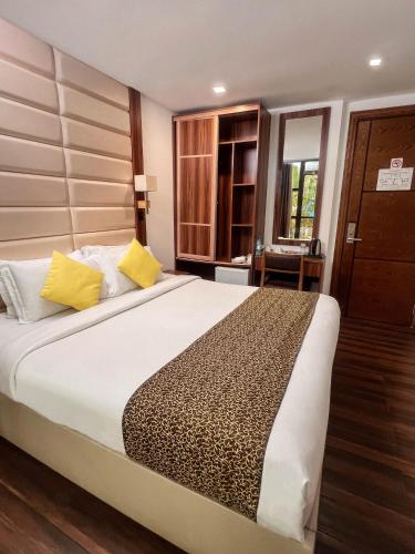 a bedroom with a large bed with yellow pillows at Dreams Grand in Hulhumale