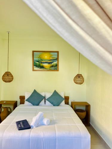 a bedroom with a large white bed with blue pillows at New Yêu Biển homestay in Vĩnh Hy