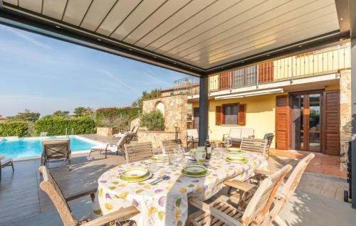a patio with a table and chairs and a pool at Lovely Home In Castiglione Del Lago in Castiglione del Lago