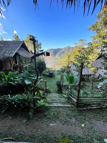 a garden with a path leading to a hut at ecolodge khamu homestay guesthouse in Ban Pang Hat
