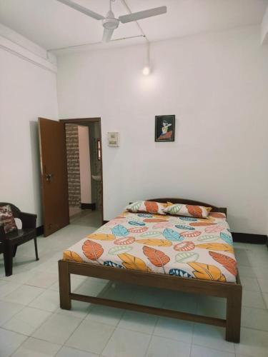 a bed in a room with a ceiling fan at Primrose Homestay in Guwahati