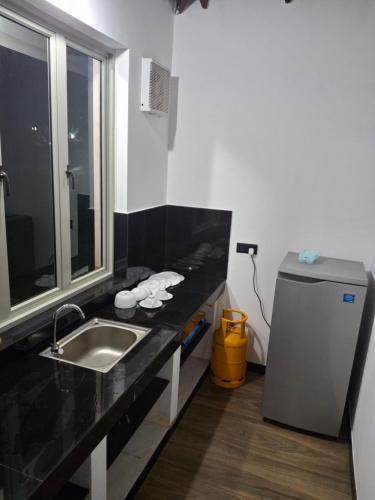 a bathroom with a sink and a refrigerator at Debaraliyadda Estate in Pannala