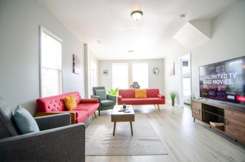 a living room with red couches and a flat screen tv at Near NYC Spacious 4 bedroom 2 and a half bath in North Bergen