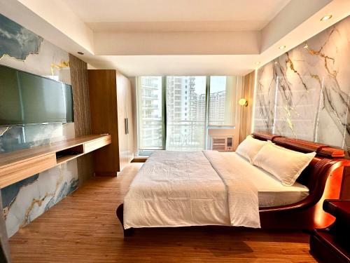 a bedroom with a large bed and a flat screen tv at Azure Urban Resort South Paranaque Beach View Unit- Newly Renovated - Near Airport Near SM Bicutan in Manila