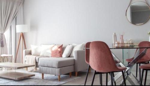 a living room with a couch and a table and chairs at Comfortable lovely apartment in Johannesburg