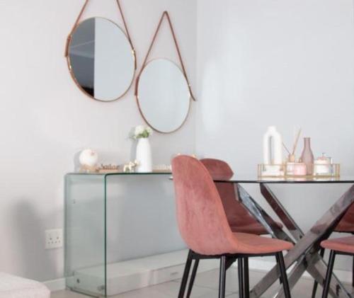 a glass table with two chairs and a mirror at Comfortable lovely apartment in Johannesburg