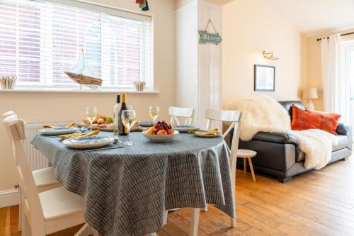 a dining room with a table with food and wine glasses at The Summerhouse in Milford on Sea