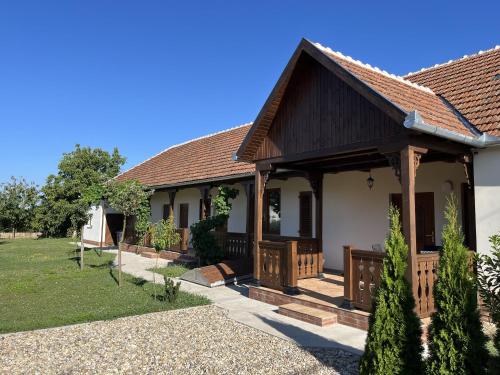 a house with a porch and a yard at Engstliz Apartman in Foeni