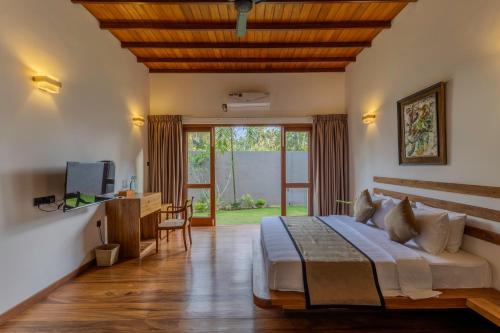 una camera con letto, scrivania e TV di Mudliyar House a Hikkaduwa
