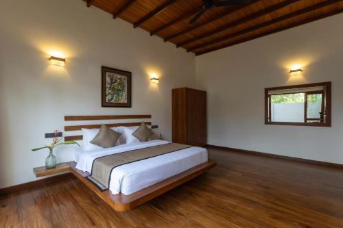 una camera da letto con un letto grande e una finestra di Mudliyar House a Hikkaduwa