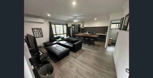 una sala de estar con un sofá y una mesa en Island Haven Wood, en Russell Island