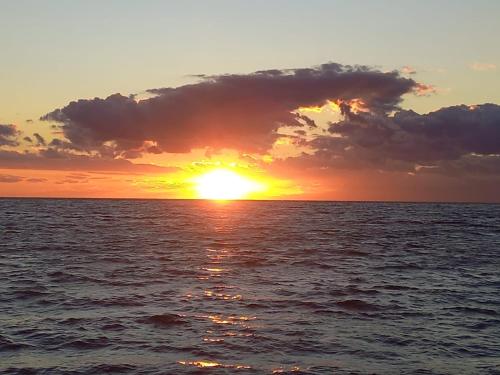 a sunset over the ocean with the sun setting at Appartamento in Residence La Vela in Palizzi Marina
