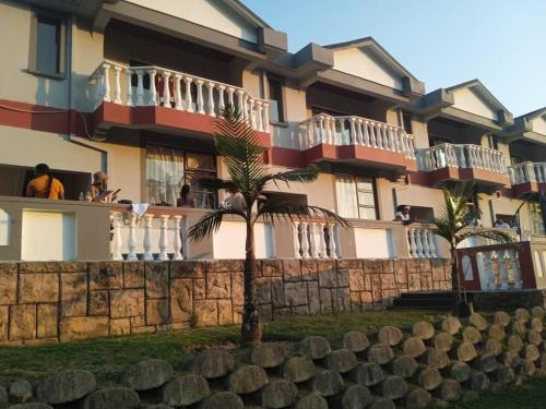 a building with balconies and palm trees in front of it at THE HAVEN GUEST HOUSE NKOYOYO in Mbabane