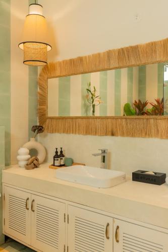 a bathroom with a sink and a mirror at ELIVAAS 4 BHK Villa with Pvt Pool & Jacuzzi-Yashgeet in Siolim