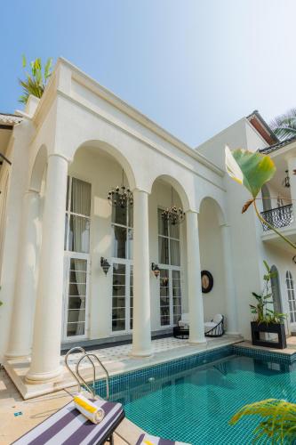 a villa with a swimming pool and a house at ELIVAAS 4 BHK Villa with Pvt Pool & Jacuzzi-Yashgeet in Siolim