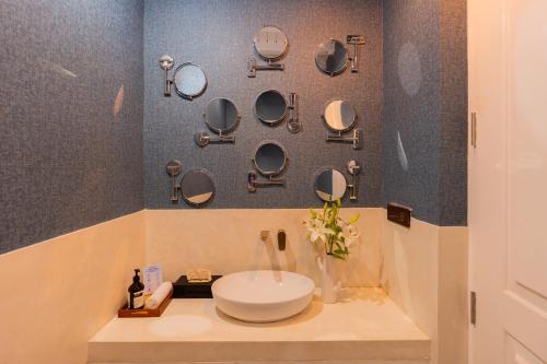 a bathroom with a sink and mirrors on the wall at ELIVAAS 4 BHK Villa with Pvt Pool & Jacuzzi-Yashgeet in Siolim