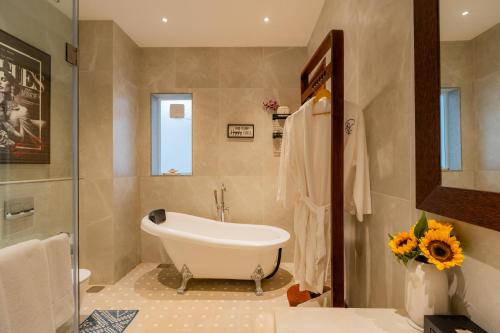 a bathroom with a bath tub and a sink at ELIVAAS 4 BHK Villa with Pvt Pool & Jacuzzi-Yashgeet in Siolim